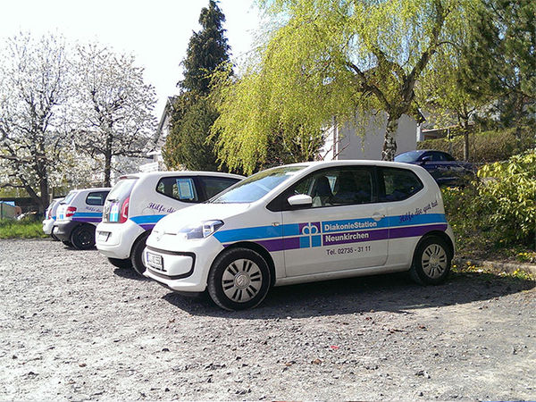 Fuhrpark der Diakonie Neunkirchen auf einem Schotter-Parkplatz